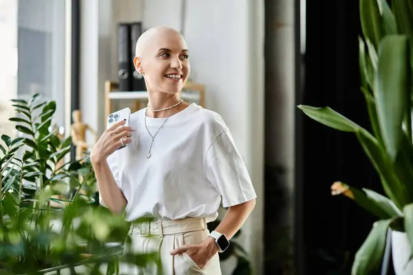 A young woman with a shaved head radiates confidence in stylish attire surrounded by plants. — Stock Photo