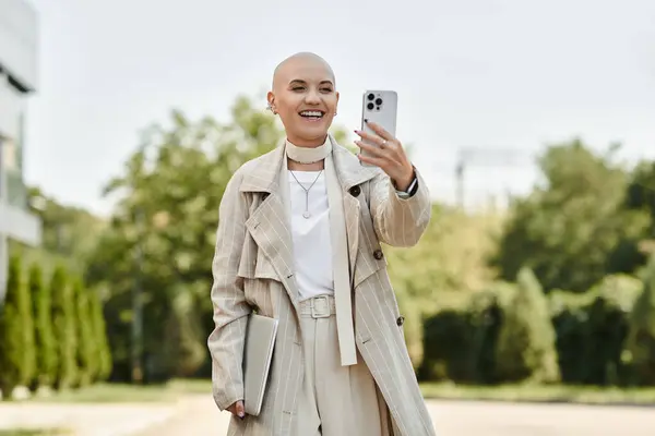 Brightly dressed, a young bald woman smiles joyfully as she captures a moment outdoors. — Stock Photo