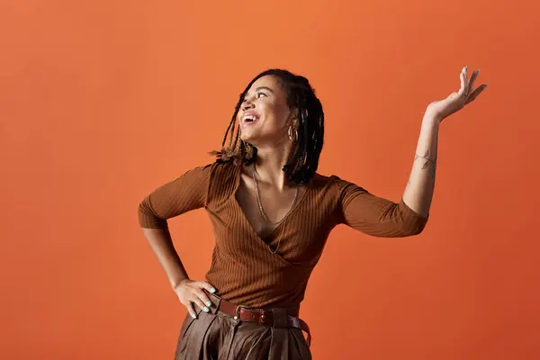 Uma jovem e elegante mulher afro-americana com cabelo trançado abraça seu estilo, irradiando confiança em um estúdio. — Fotografia de Stock