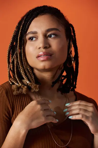 Uma jovem mostra seu cabelo trançado e estilo único enquanto posando em um ambiente de estúdio brilhante. — Fotografia de Stock