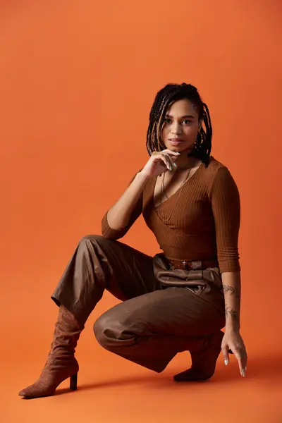 Uma jovem elegante mostra seu penteado trançado enquanto posando com confiança em um estúdio vibrante. — Fotografia de Stock