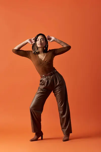 Une jeune femme à la mode aux cheveux tressés se tient en confiance, capturant l'attention avec son style unique. — Photo de stock