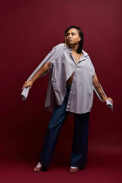 A fashionable young African American woman showcases her vibrant style in a bold studio setting. — Stock Photo