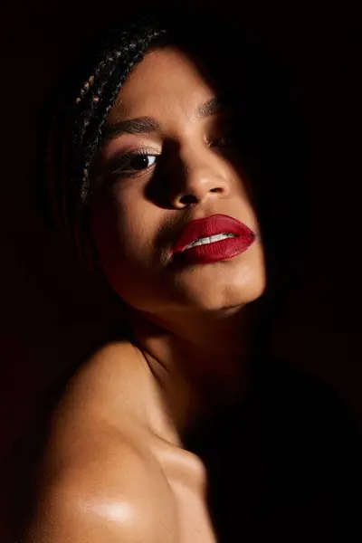 A fashionable young woman with striking red lips radiates confidence while posing in a studio setting. — Stock Photo