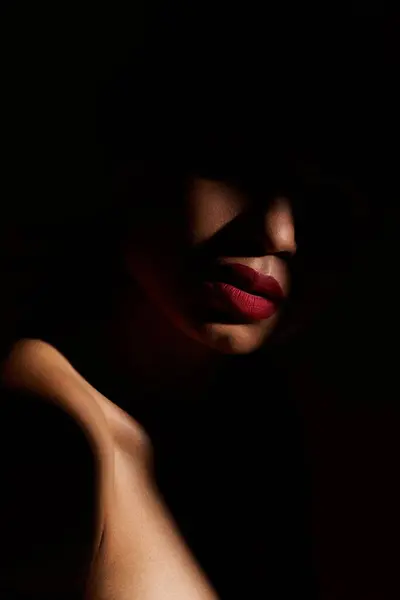 A young African American woman showcases her unique style with vibrant red lips and a confident pose in a studio. — Stock Photo