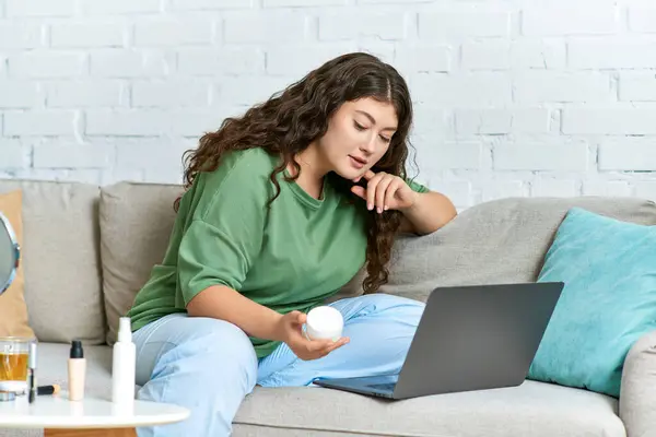 Eine junge Plus-Size-Frau mit lockigem Haar erkundet ihre Beauty-Routine zu Hause, umgeben von Make-up-Produkten. — Stockfoto