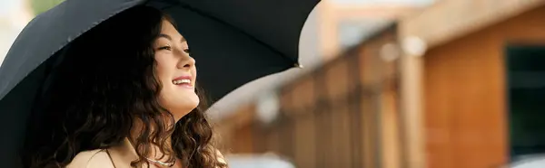 A young woman in a stylish black dress and beige coat, savoring the rainy day. — Stock Photo