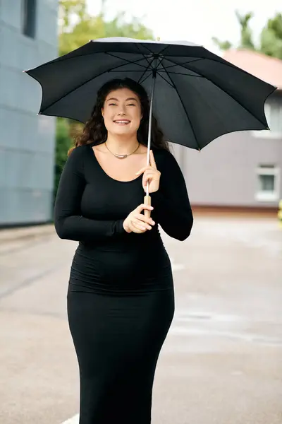 A cheerful plus size woman walks along an outdoor path, enjoying the crisp autumn air while holding an umbrella. — Stock Photo