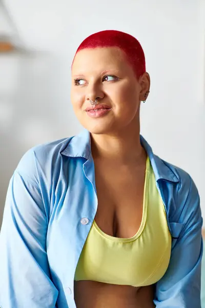 A young woman at home smiles warmly while wearing vibrant colors and feeling comfortable. — Stock Photo