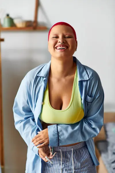 Una joven con vibrantes vigas de pelo con felicidad en su confortable entorno hogareño. - foto de stock