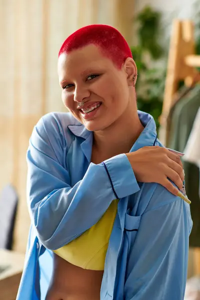 A cheerful young woman smiles warmly in her stylish home, radiating positive energy and comfort. — Stock Photo