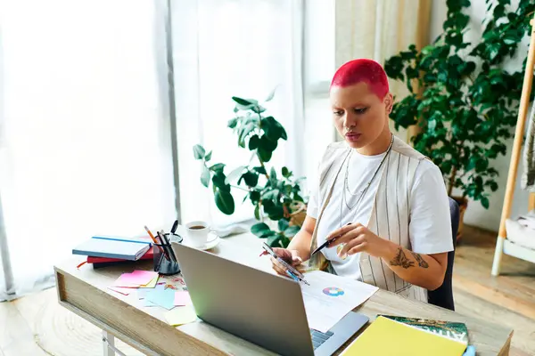 A young woman engages in artistic work at her home desk filled with vibrant materials and plants. — Stock Photo