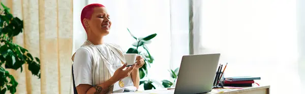 La giovane donna sorride soddisfatta, sorseggiando il suo drink in un luminoso ufficio domestico pieno di verde. — Foto stock
