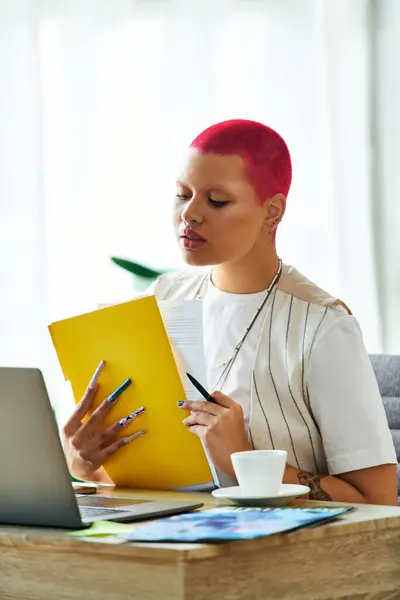 A young woman in a bright home office sips coffee and reviews papers in style. — Stock Photo