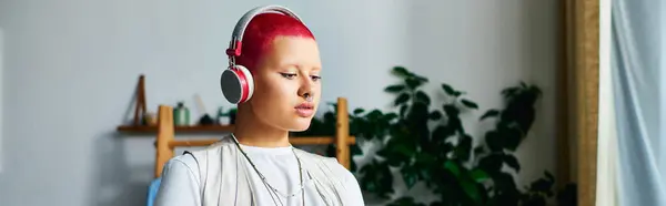 Uma jovem com um cabelo ruivo impressionante mergulha na música, desfrutando de um momento tranquilo dentro de casa. — Fotografia de Stock