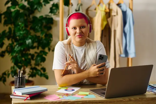A young woman with bright pink hair works on creative projects while enjoying her home environment. — Stock Photo