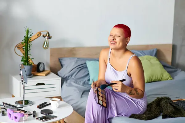 A cheerful young woman smiles while getting ready with makeup tools in her stylish bedroom. — Stock Photo