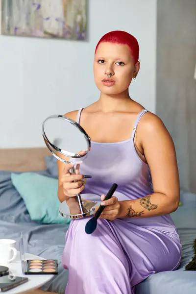 With a mirror in hand, the woman showcases her artistry and bold look in the comfort of home. — Stock Photo