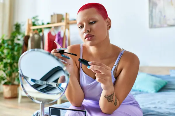 A young woman prepares for her day by applying mascara in a relaxed and stylish home environment. — Stock Photo