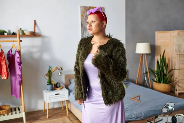 A young woman showcases her unique fashion sense in a vibrant, personalized living space. — Stock Photo