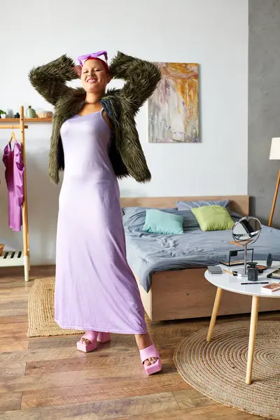 Inside her cozy space, a young woman joyfully showcases her fashion sense while posing. — Stock Photo
