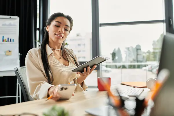 A young woman thoughtfully examines her notes while seated at a stylish office desk. — Stock Photo