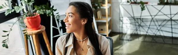 A young woman exudes joy as she engages in work within a vibrant office environment. — Stock Photo