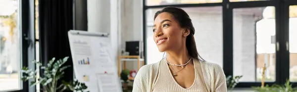 Bright natural light illuminates a young woman as she engages thoughtfully in her work environment. — Stock Photo