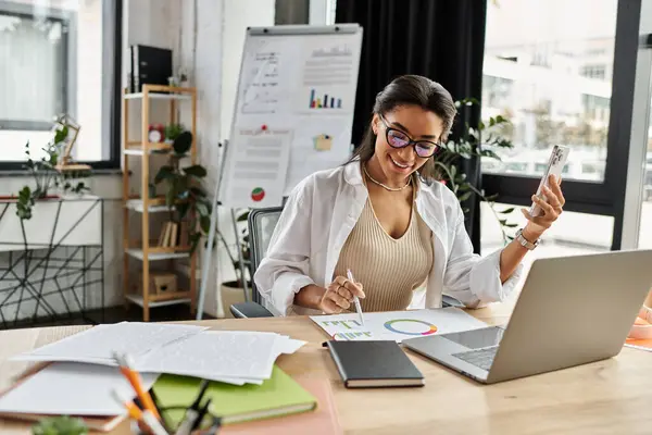 A beautiful woman engages with charts and digital tools while enhancing her workspace. — Stock Photo