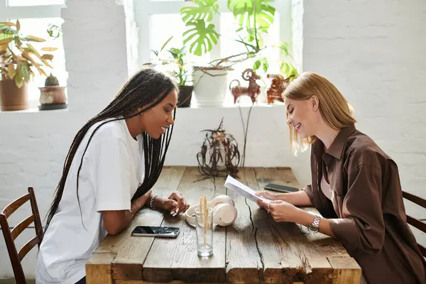 Two women share smiles and stories at a cafe, creating special moments filled with love and warmth. — Stock Photo