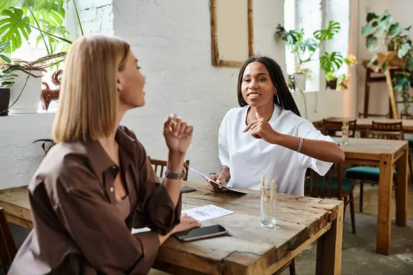 A joyful moment unfolds as a multicultural couple shares smiles and conversations at their favorite cafe. — Stock Photo