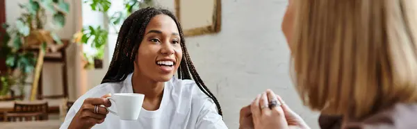 Un beau couple multiculturel profite de l'autre compagnie, sirotant du café et partageant des sourires dans un café — Photo de stock