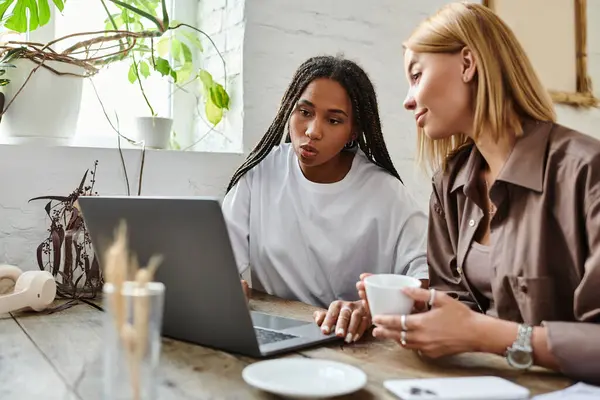 Zwei Frauen genießen einen entspannten Nachmittag in einem Café, lächeln und teilen Momente, während sie Getränke schlürfen. — Stockfoto