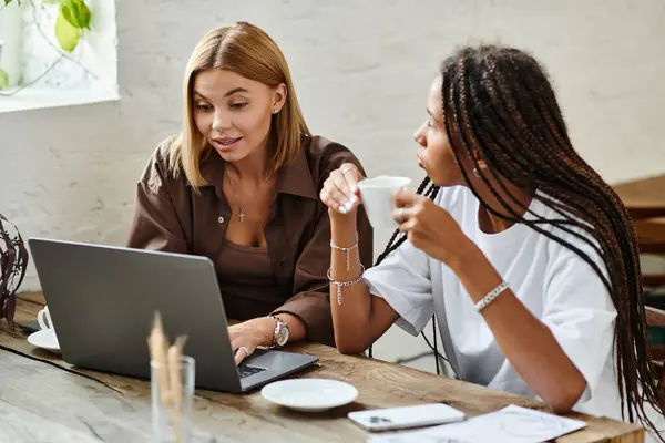 Two women enjoy quality time together at a cafe, sharing smiles and conversation over coffee. — Stock Photo