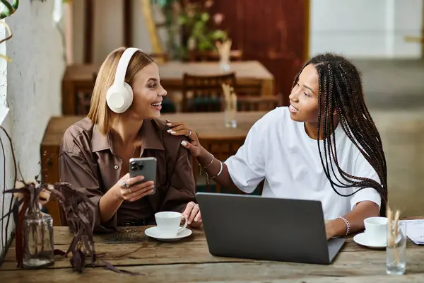 A smiling African American woman engages with her girlfriend, enjoying brunch at a vibrant cafe. — Stock Photo
