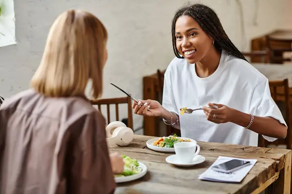 Un momento gioioso si svolge come una coppia condivide un pasto in un caffè, irradiando amore e connessione durante il brunch. — Foto stock