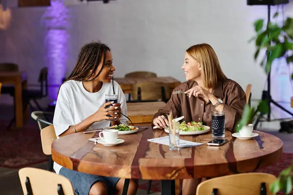 A joyful couple enjoys each other's company at a cozy cafe, sharing food and laughter while sipping drinks. — Stock Photo