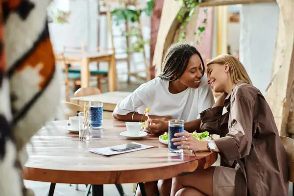 A joyful moment unfolds as two women enjoy a lunch date, sharing smiles and closeness in a quaint cafe — Stock Photo