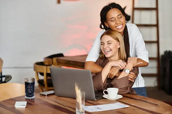 Two women share a playful moment at a cafe, enjoying each others company while sipping coffee. — Stock Photo