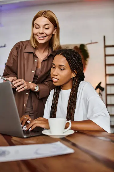 A joyful couple shares laughter and love over coffee while working on a laptop in a cozy cafe environment. — Stock Photo