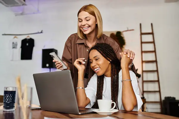 Una gioiosa coppia lesbica multietnica si gode il loro tempo insieme, sorridendo e condividendo risate in un caffè — Foto stock