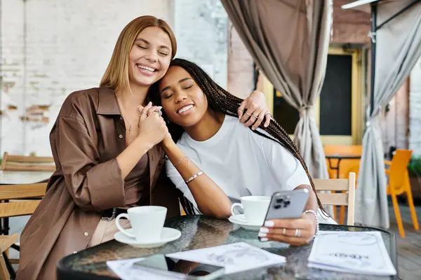 A smiling couple shares a tender moment over coffee at a cafe, embracing the warmth of love and connection. — Stock Photo
