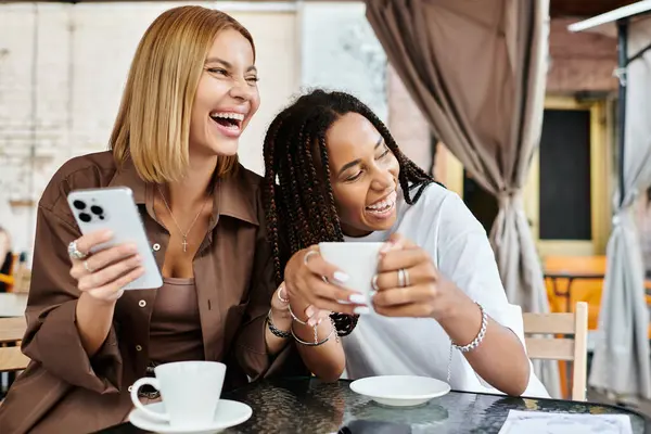 Una coppia felice ride insieme in un caffè, gustando un caffè e condividendo la loro connessione gioiosa. — Foto stock