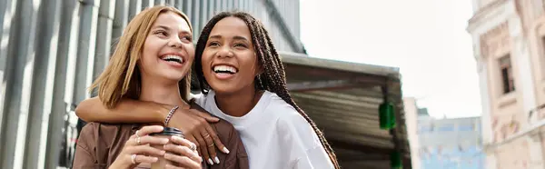 A smiling African American woman embraces her girlfriend, sharing a joyful moment together. — Stock Photo
