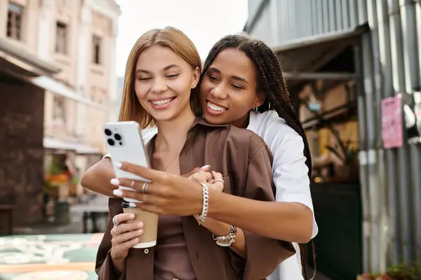 A happy African American woman with braided hair embraces her girlfriend, sharing smiles. — Fotografia de Stock