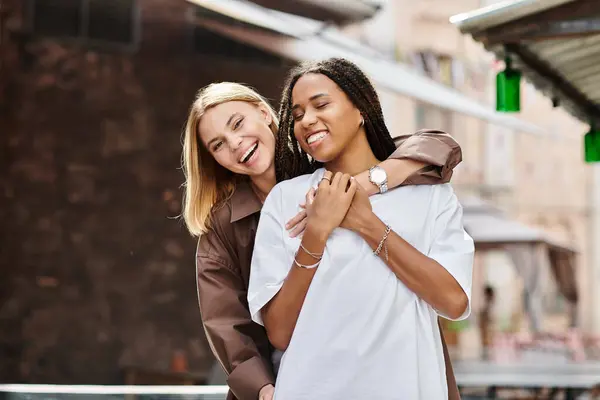 Una mujer afroamericana sonriente comparte un momento tierno con su novia, disfrutando de la vida juntos. - foto de stock