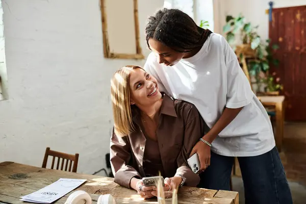 An African American woman with braided hair smiles warmly at her girlfriend during a relaxed cafe outing. — Stock Photo