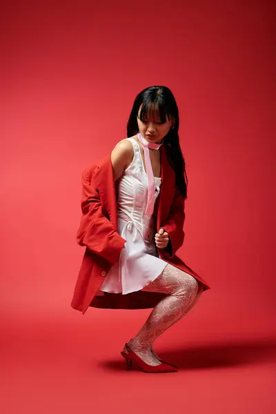 Una hermosa mujer asiática capta la atención con su elegancia y encanto en un traje llamativo. - foto de stock