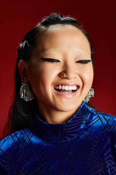 She shines with a bright smile and earrings, radiating happiness and confidence in her outfit. — Stock Photo