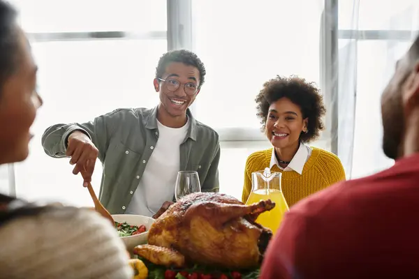 A group of friends shares delicious food and laughter while celebrating Thanksgiving at home. — Stock Photo